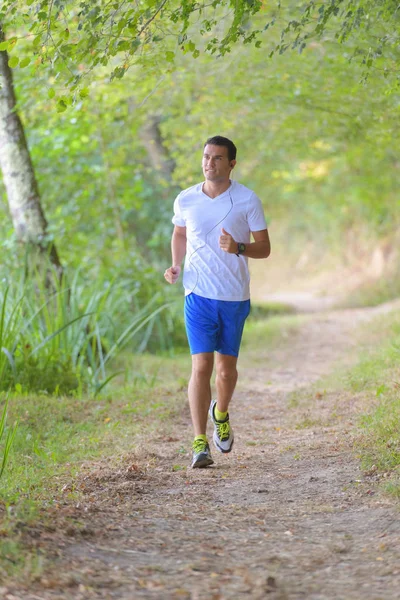 Joven corriendo en el bosque — Foto de Stock