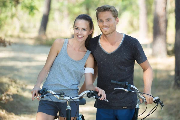 Giovane coppia su un giro in bicicletta nella foresta — Foto Stock