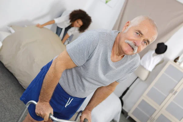 Senior mannelijke patiënt met behulp van Walker in Rehab Center — Stockfoto