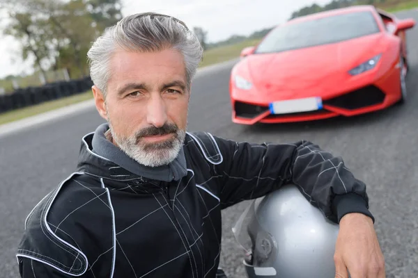 Homem posando na frente de um carro caro — Fotografia de Stock