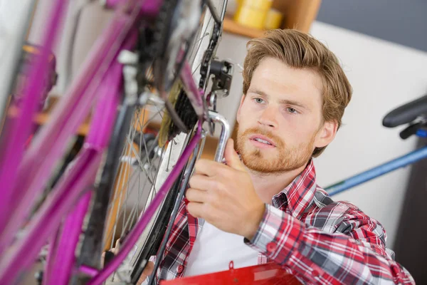 Handyman fixação roda de bicicleta em sua garagem — Fotografia de Stock
