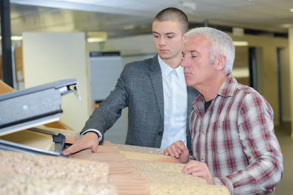 Salesman showing customer velux roof window in showroom — Stock Photo, Image