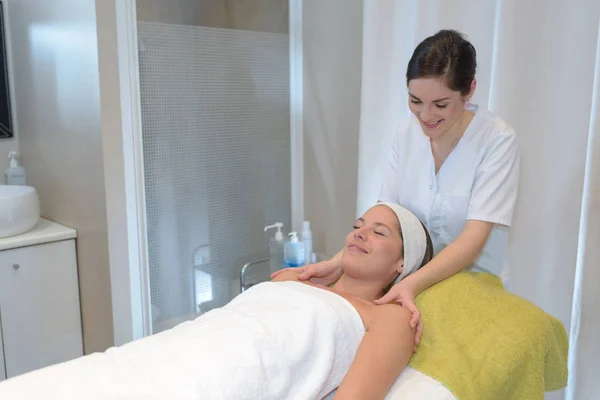 Cliente mulher recebendo massagem por esteticista feminino — Fotografia de Stock