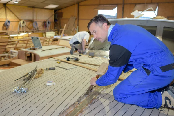 Carpinteiro fazendo barco usando cinzel e martelo — Fotografia de Stock