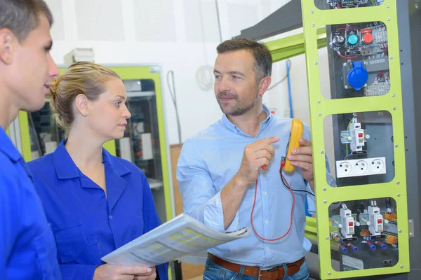 Elektriciens verifiëren van spanning in een gedeeltelijk gemonteerde elektrische aansluiting — Stockfoto