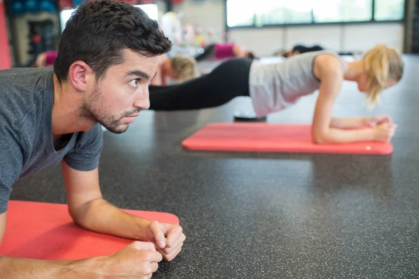 Grupp människor arbetar deras abs i gym — Stockfoto