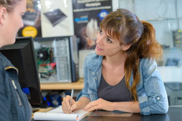 Verkäuferin macht sich Notizen vom Kunden — Stockfoto