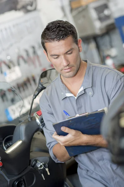 Mechanic writing a report — Stock Photo, Image
