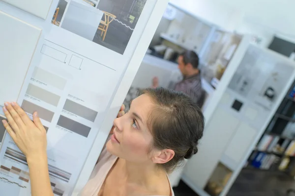 Mulher olhando para o amostrador de cores na loja de móveis — Fotografia de Stock
