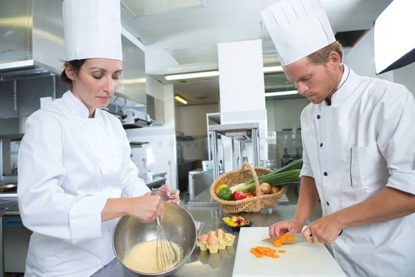 Chef masculino y femenino que trabaja en la cocina — Foto de Stock