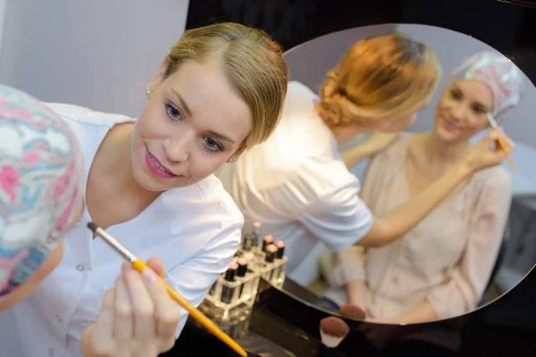 Esteticista aplicación de maquillaje a la mujer en el pañuelo para la cabeza — Foto de Stock