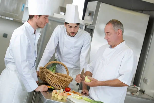 Tirocinanti dello chef osservando il suo lavoro — Foto Stock