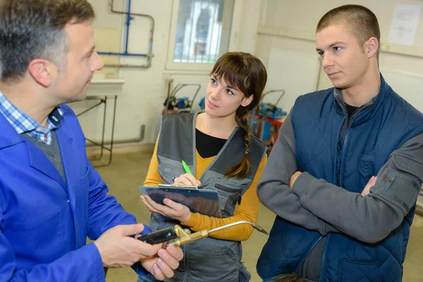 Smederijen leraar studenten te zien hoe veilig gebruik gas lasser — Stockfoto