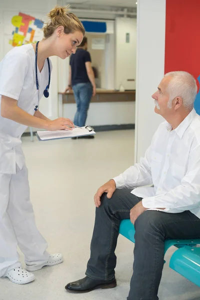 Krankenschwester holt sich Informationen vom wartenden Patienten — Stockfoto