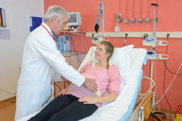Schwangere konsultiert Arzt Weiß sitzt in Klinik — Stockfoto