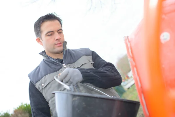 Uomo che pulisce un'auto con un secchio — Foto Stock