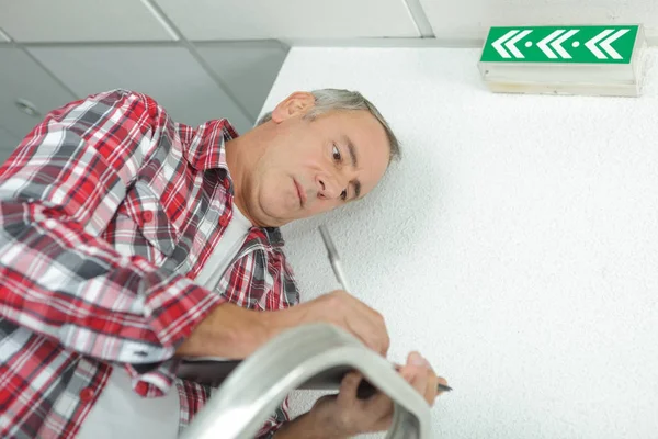 Pensive builder writing on clipboard — Stock Photo, Image