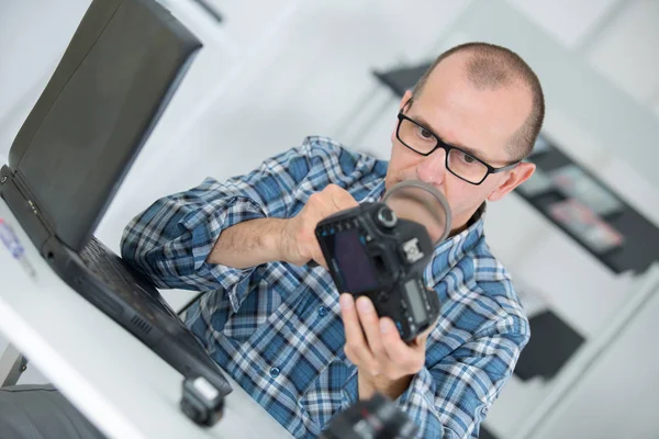Arbeiter untersucht eine Digitalkamera — Stockfoto