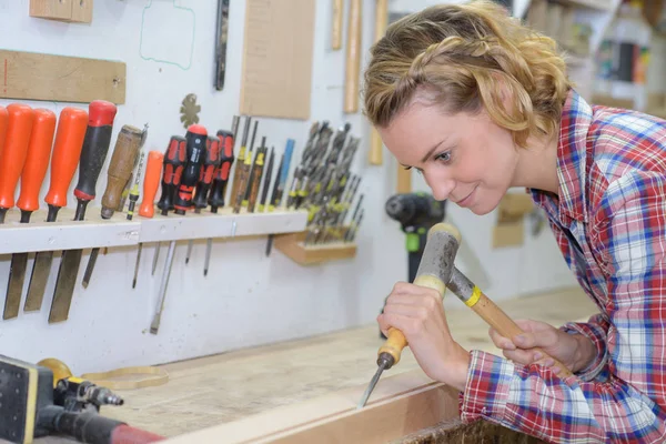 Craftswoman werken met beitel en hamer in haar atelier — Stockfoto