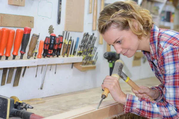 Artesã trabalhando com cinzel e martelo em sua oficina — Fotografia de Stock