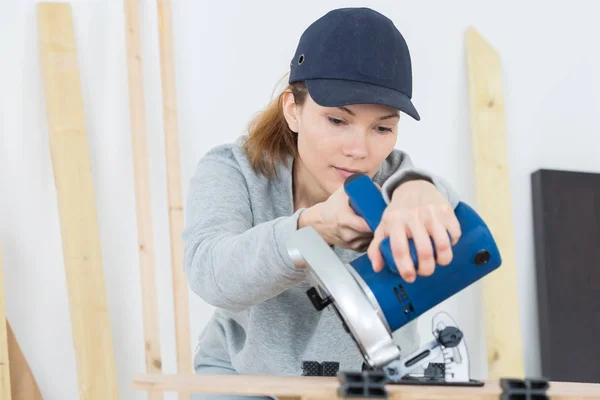 Carpinteiro feminino usando lixadeira elétrica — Fotografia de Stock