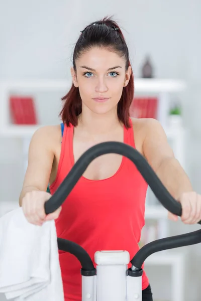 Retrato de jovem senhora na máquina de exercício — Fotografia de Stock