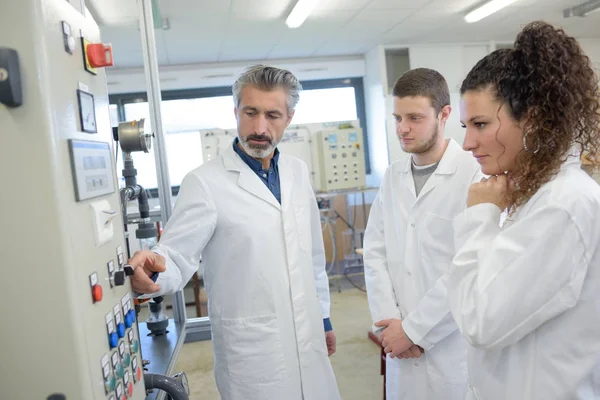 Ingeniero mostrando controles de maquinaria a los estudiantes — Foto de Stock