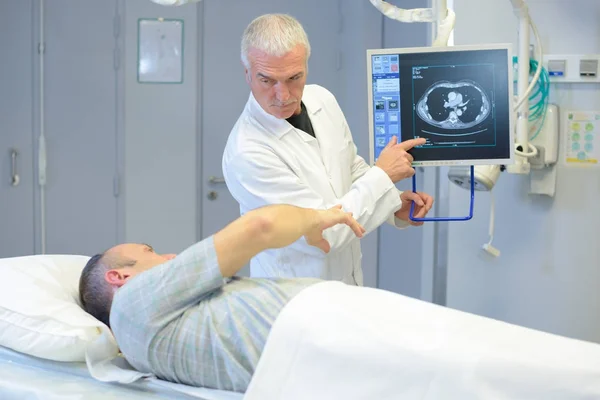 Doctor explaining image on screen to patient — Stock Photo, Image