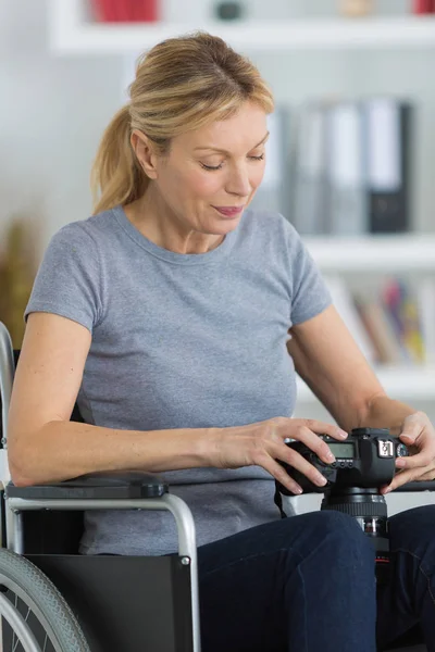 Frau sitzt mit Kamera im Rollstuhl — Stockfoto