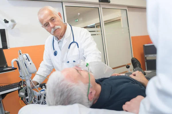 Médico que ayuda al paciente con la máscara respiratoria — Foto de Stock