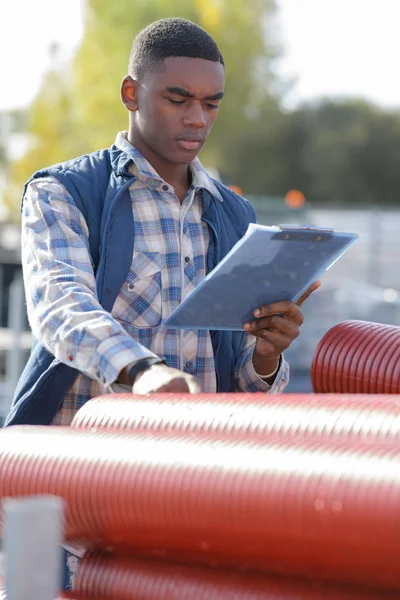 Arbeiter in Schutzanzügen vor Industrierohren — Stockfoto