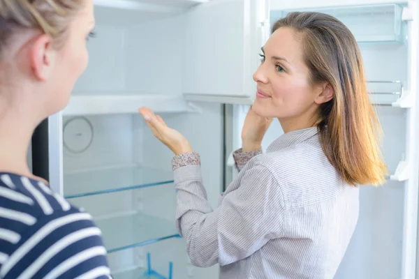 Rivenditore che mostra il frigorifero al cliente — Foto Stock