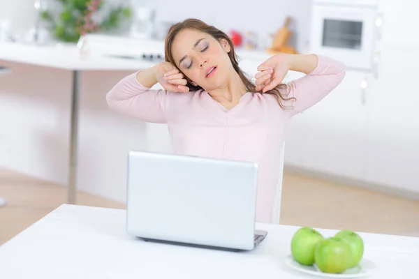 Lady sat at laptop, stretching — Stock Photo, Image