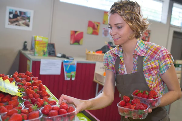 Werknemer verkoop aardbeien en vrouw — Stockfoto