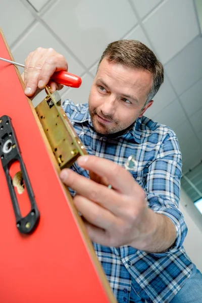 Hombre insertando un mecanismo de cerradura de puerta — Foto de Stock