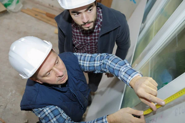 Constructor que mide ventanas y hombre —  Fotos de Stock