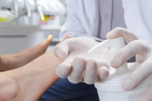 Pedicurist putting handcream and pedicurist — Stock Photo, Image