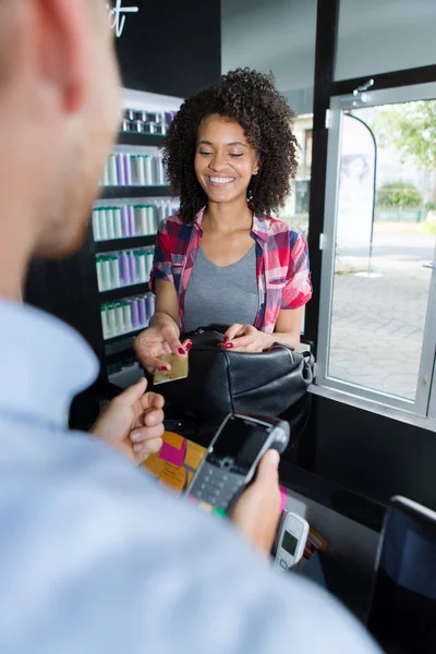 Peluquería con cliente masculino pagando con tarjeta de crédito — Foto de Stock