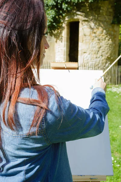 Een vrouw schilderen van een foto in de tuin — Stockfoto