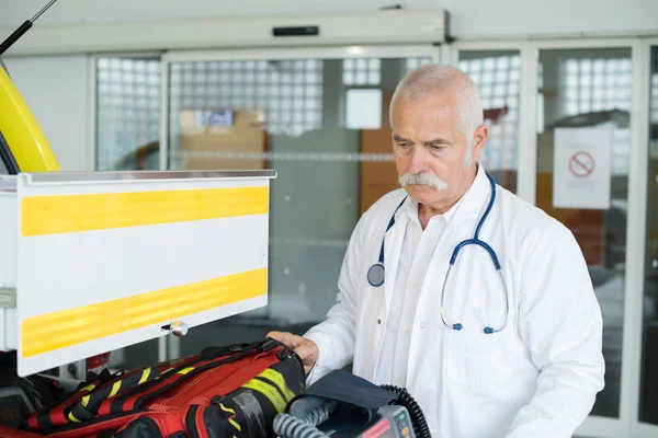 Bir ambulans yanındaki kıdemli doktor — Stok fotoğraf