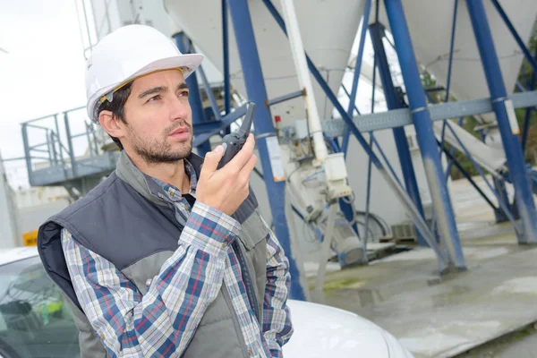 Man in cementfabriek met behulp van de walkie talkie — Stockfoto