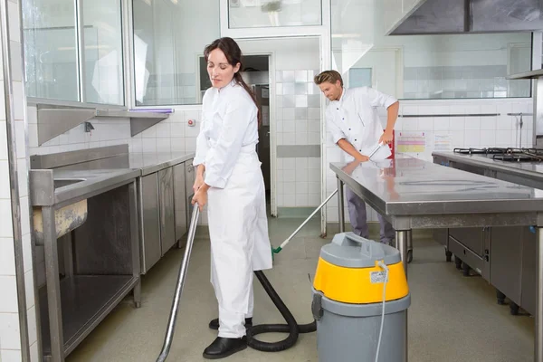 Casal limpeza de superfícies de cozinha e armários juntos — Fotografia de Stock