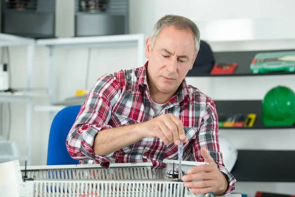 Porträt eines männlichen Klempners, der Wasserkühler repariert — Stockfoto