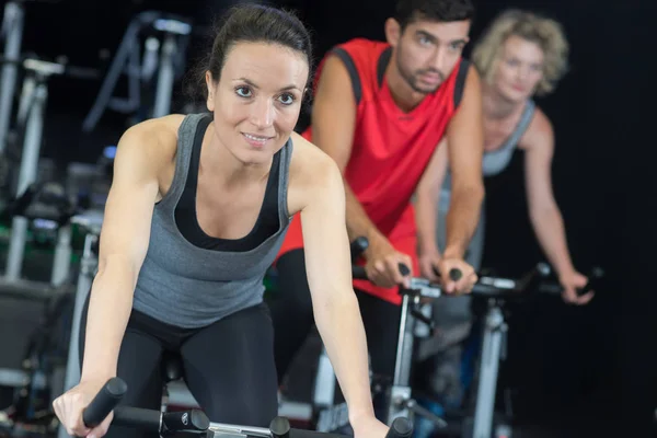 Les personnes qui s'entraînent ensemble sur les vélos d'appartement — Photo