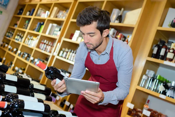 Vendedor sonriente hombre en la tienda de vinos —  Fotos de Stock