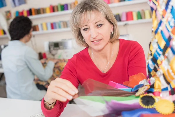 Giovane sarta donna che sceglie materiale — Foto Stock