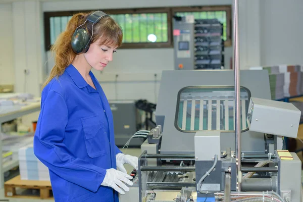 Mulher operando máquina industrial — Fotografia de Stock