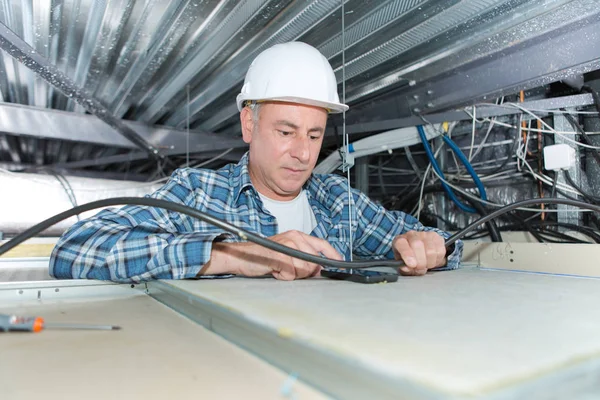 Mature électricien câblage intérieur plafond — Photo