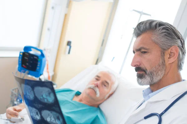 Лікар показує пацієнту свої рентгенівські результати — стокове фото