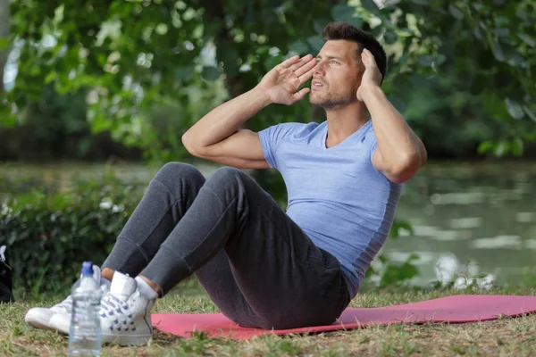 Man doing sit-ups in the forest — Stock Photo, Image